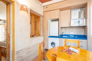 A compact kitchen with a washing machine, a microwave, and a sink.
