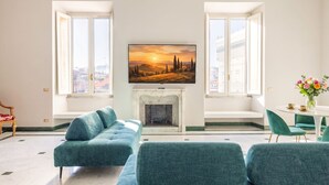 En stue med pejs, to vinduer, en sofa og et spiseområde.