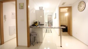 A modern kitchen with a central island, stainless steel appliances, and a clock on the wall. - Varudi1.09 (Torrevieja)