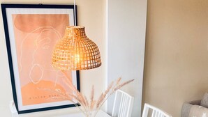 A white dining table with a woven lamp, white chairs, and a framed artwork on the wall. - Duplez Zenia Beach (Orihuela)