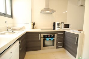 A modern kitchen with a dishwasher, oven, microwave, and a coffee maker. - Ground Floor Oasis Beach IV (Orihuela)