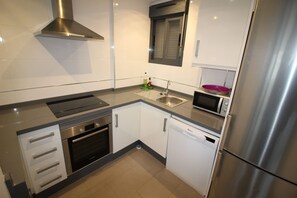 A modern kitchen with stainless steel appliances, a microwave, and a dishwasher. - Ground Floor Oasis Beach IV (Orihuela)