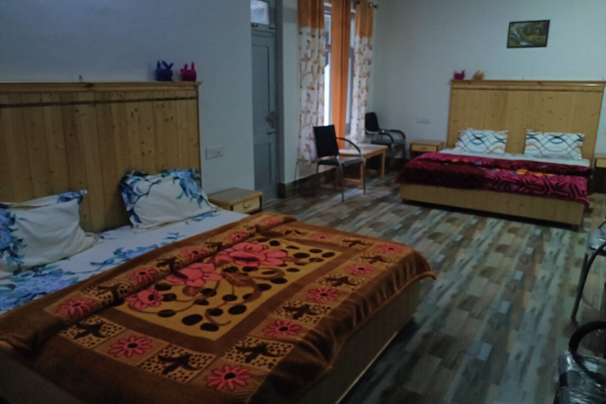 A room with two beds, a desk, and a chair.