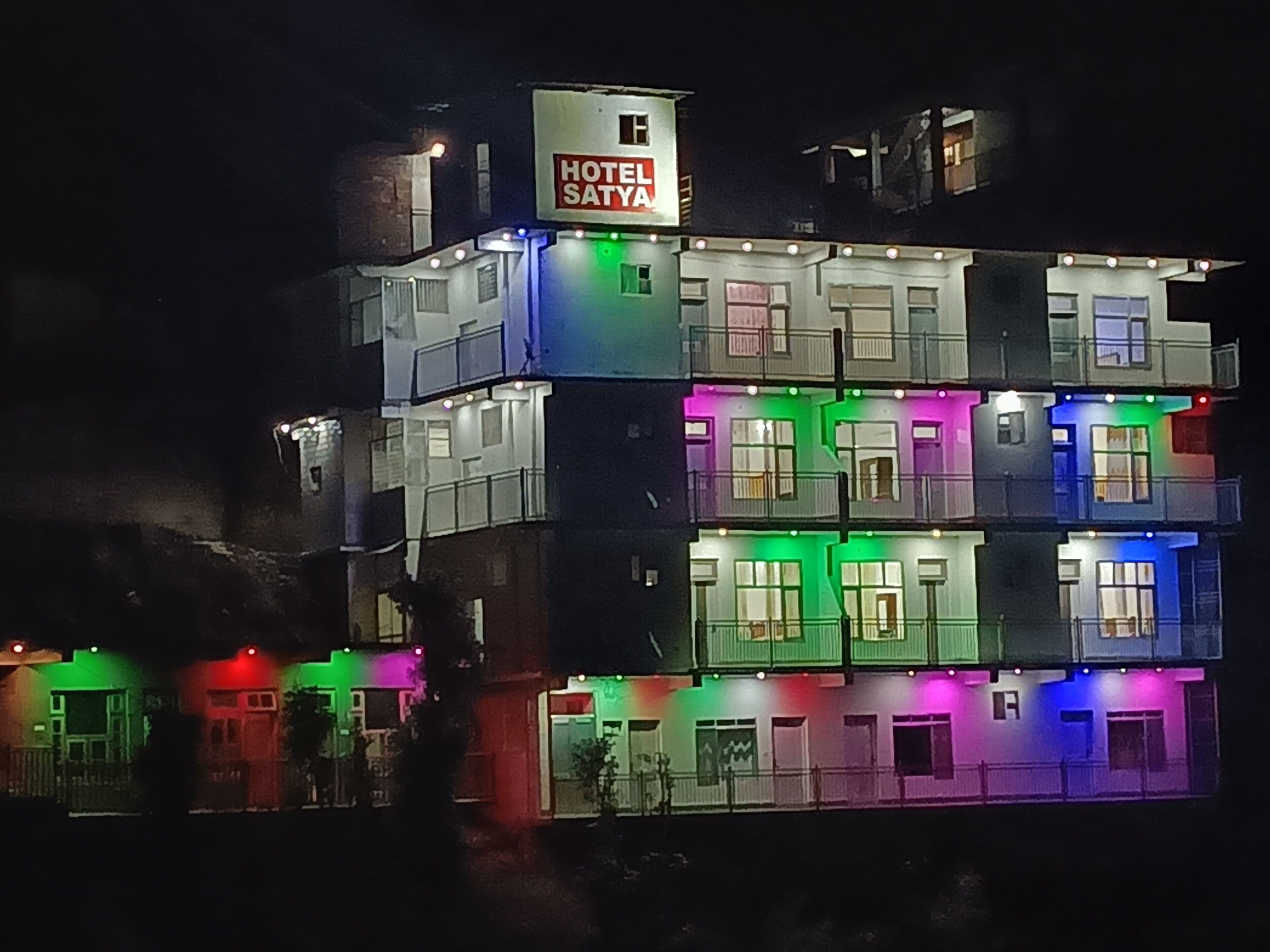 A multi-story building with a sign reading 'HOTEL SATYA' at the top.