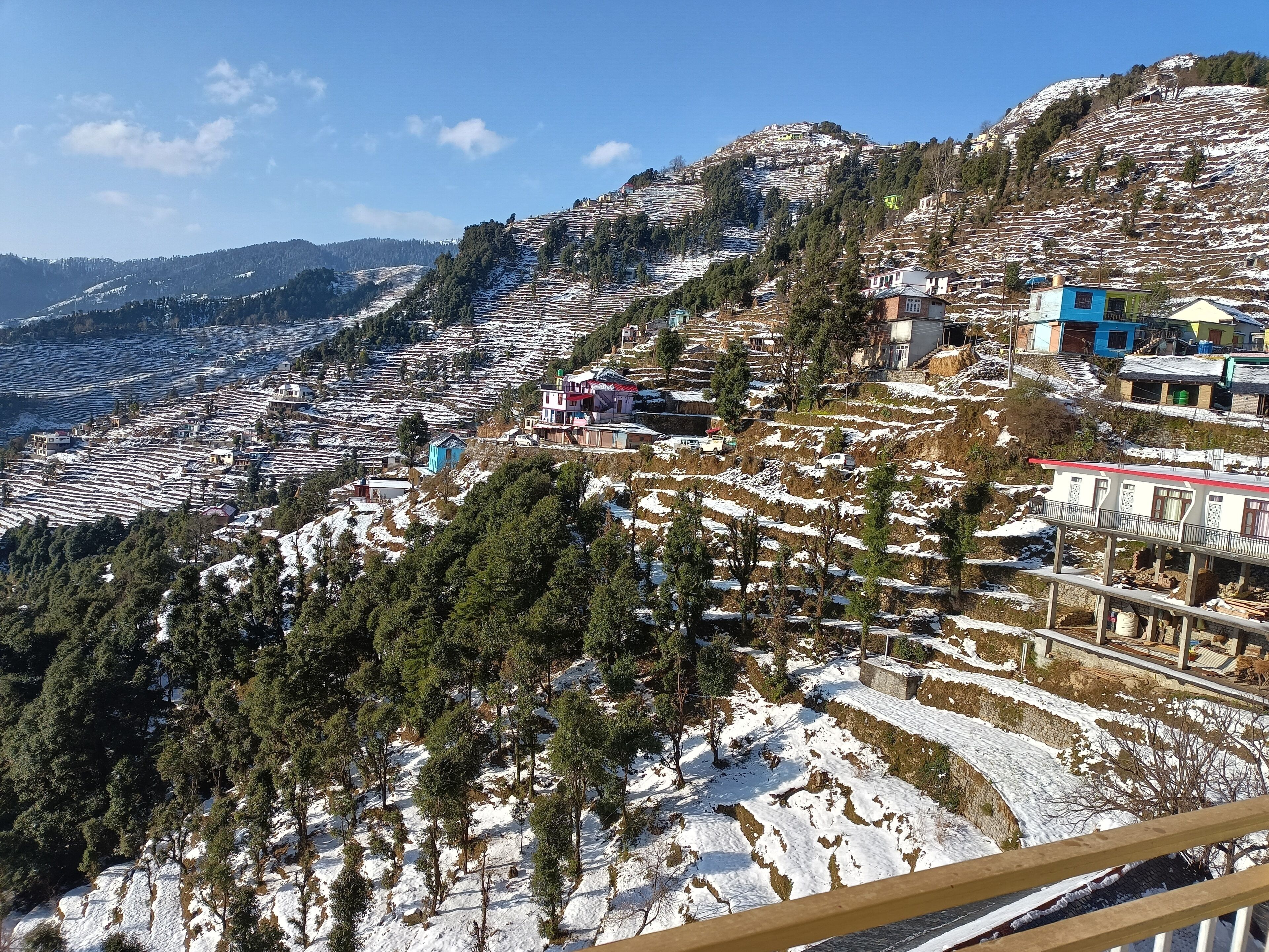 A mountainous landscape with terraced fields and scattered buildings.