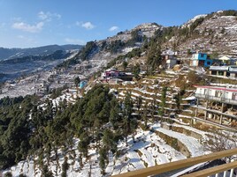 Paisaje montañoso con campos en terrazas y edificios dispersos.