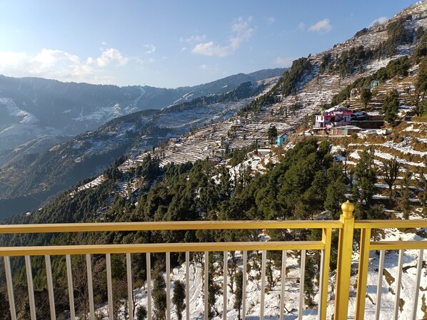 Un paisaje montañoso con campos en terrazas y edificios dispersos.
