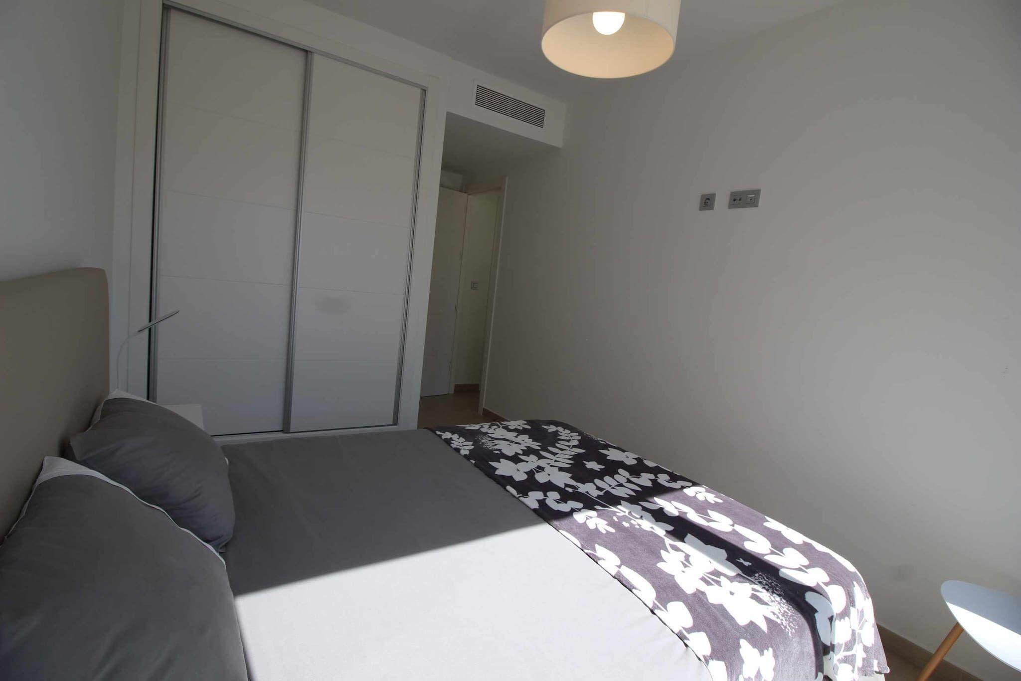 Ein Schlafzimmer mit einem Bett, einem Kleiderschrank und einem Sessel.