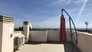 A rooftop terrace with a satellite dish, an air conditioning unit, and a red umbrella. - House Tindra Homes Punta Prima (Torrevieja)