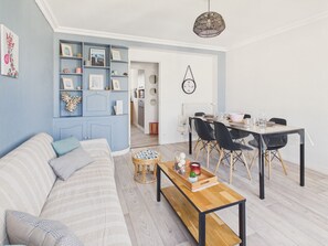 Ein modernes Wohnzimmer mit einer Couch, einem Esstisch und einem Couchtisch.