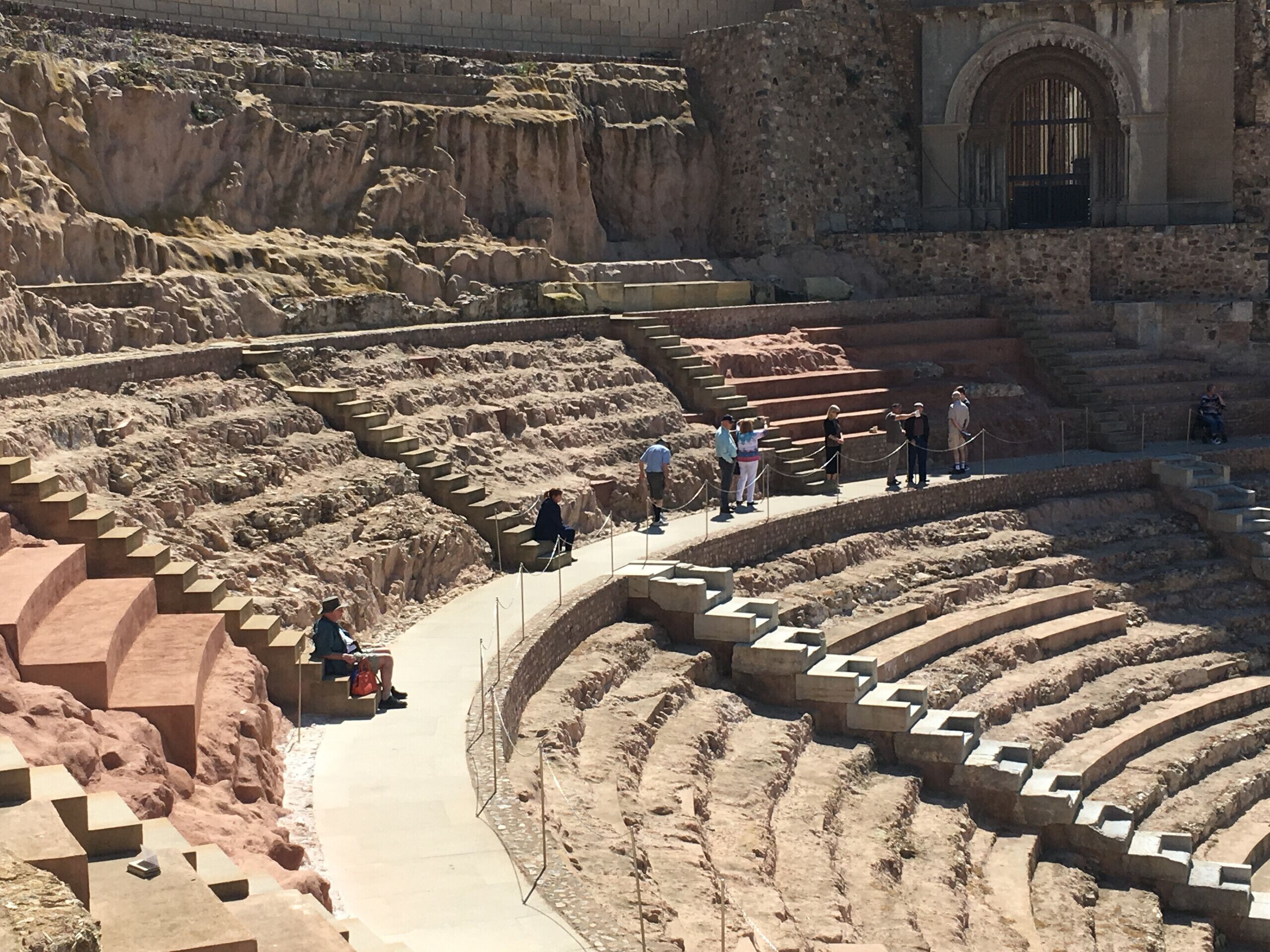 An ancient amphitheater with tiered seating and a central stage.