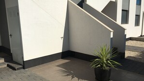 A building exterior with a staircase, a potted plant, and a tiled ground. - Groundfloor Oasis Beach Punta Prima IX (Torrevieja)