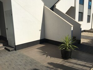 A building exterior with a staircase, a potted plant, and a tiled ground. - Groundfloor Oasis Beach Punta Prima IX (Torrevieja)