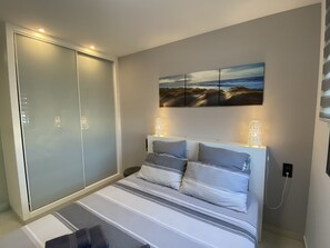 Ein Schlafzimmer mit einem Bett, einem Bild und einem Kleiderschrank.