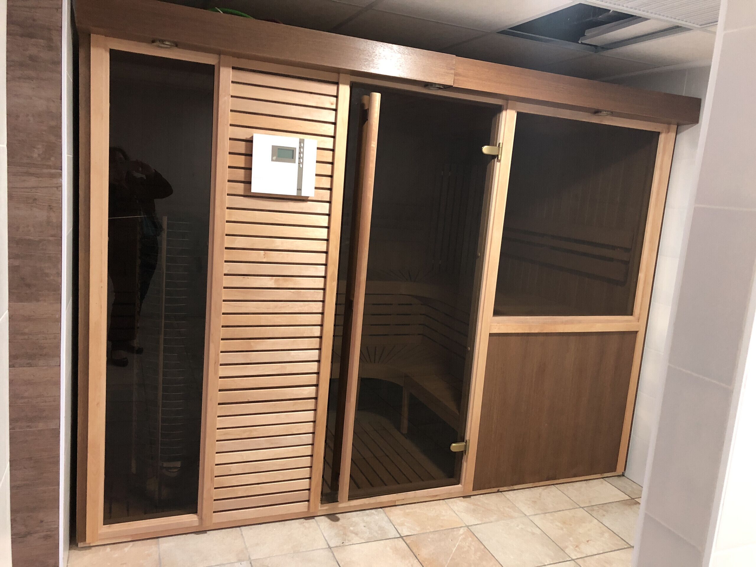 A sliding glass door with a wooden frame and a control panel.