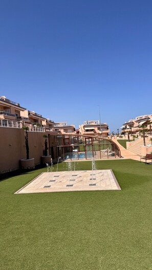 A hotel with multiple balconies, a swimming pool, and a fountain. - Penthouse Punta Prima Vistazul (Torrevieja)