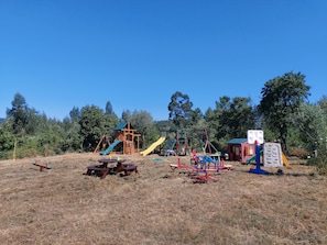 Un parque infantil con diversas estructuras de juego, incluyendo toboganes y columpios.