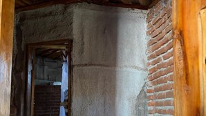 Un pasillo estrecho con techo de madera y paredes de ladrillo.