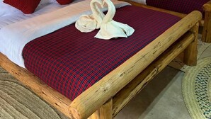 Una habitación con dos camas, cada una con colcha a cuadros rojos y negros, almohadas blancas y dosel blanco.