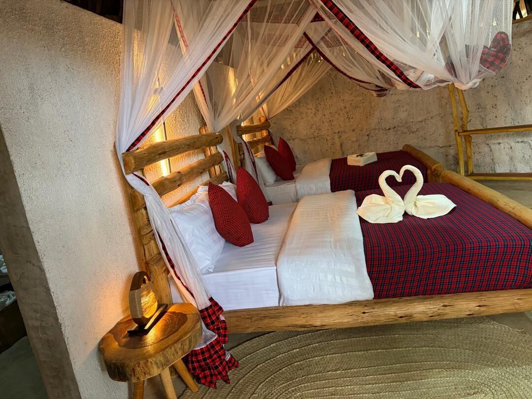 A bed with a canopy, pillows, and a blanket.