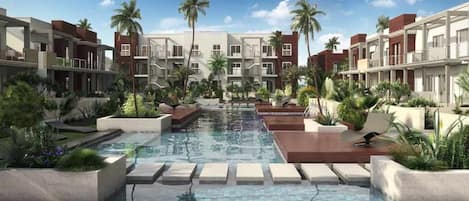 A modern hotel with a central pool, surrounded by lush greenery and palm trees.