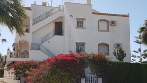 A multi-story building with a white facade, a staircase, and balconies. - Penthouse Villamartin Laplaza Destino (Orihuela)