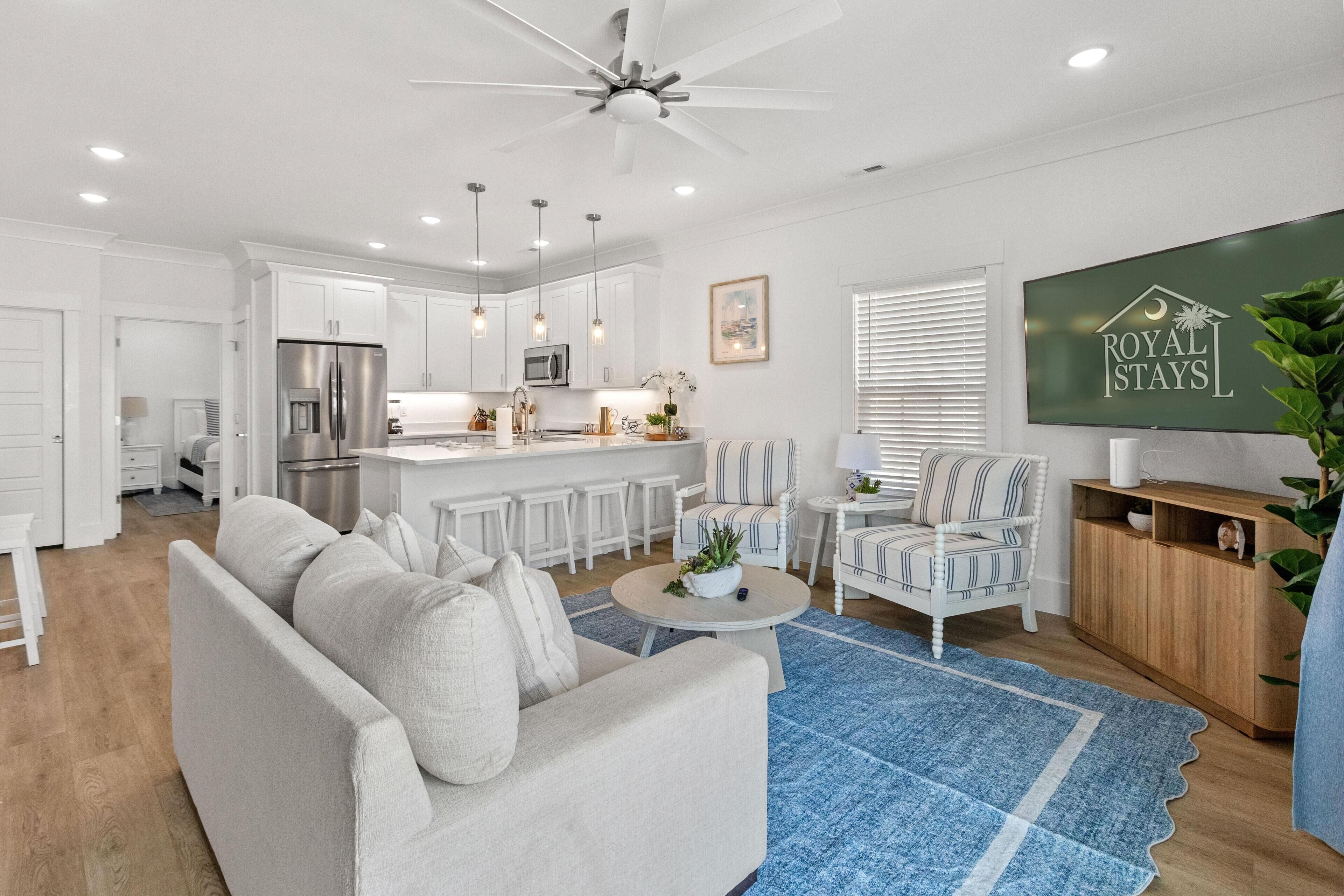 A modern kitchen with white cabinets, a stainless steel refrigerator, and a central island.