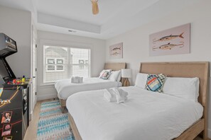 A hotel room with two beds, a desk, a television, and artwork on the walls. - Beachwalk Club Steps to Beach Sleeps 16 Pets (Myrtle Beach)