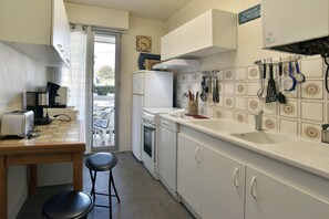 Eine kleine Küche mit einem Toaster, einer Spüle und einem Kühlschrank. Ein Fenster bietet Blick ins Freie.