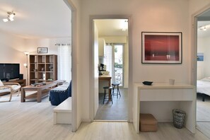 Ein modernes Wohnzimmer mit Fernseher, Bücherregal und einer Sitzecke.