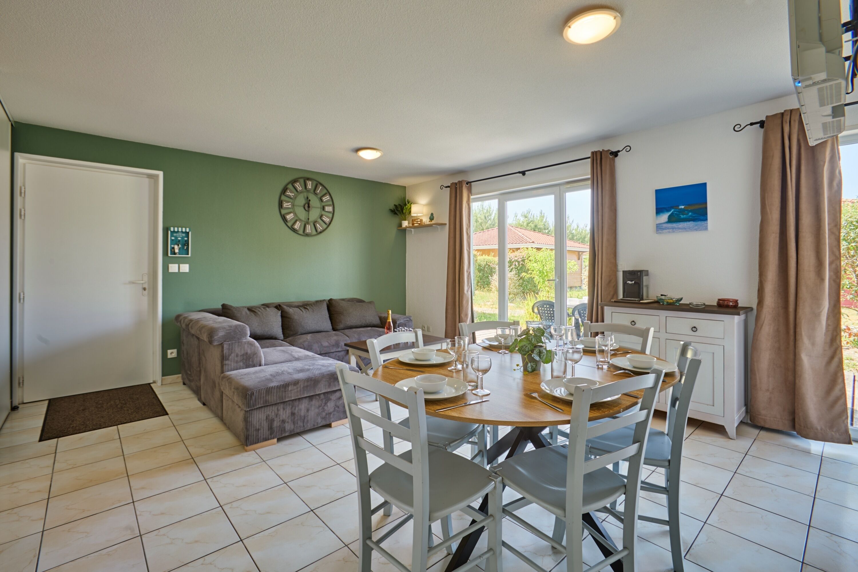 Una sala acogedora con sofá, una mesa de comedor para cuatro personas y una cocina con microondas.