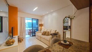Una sala moderna con sofá, mesa de comedor y un balcón con vistas.