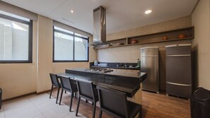 Una cocina moderna con una isla central, electrodomésticos de acero inoxidable y un ventanal grande.