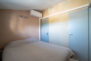 Ein Schlafzimmer mit einem Bett, einem Kleiderschrank und einer Klimaanlage.