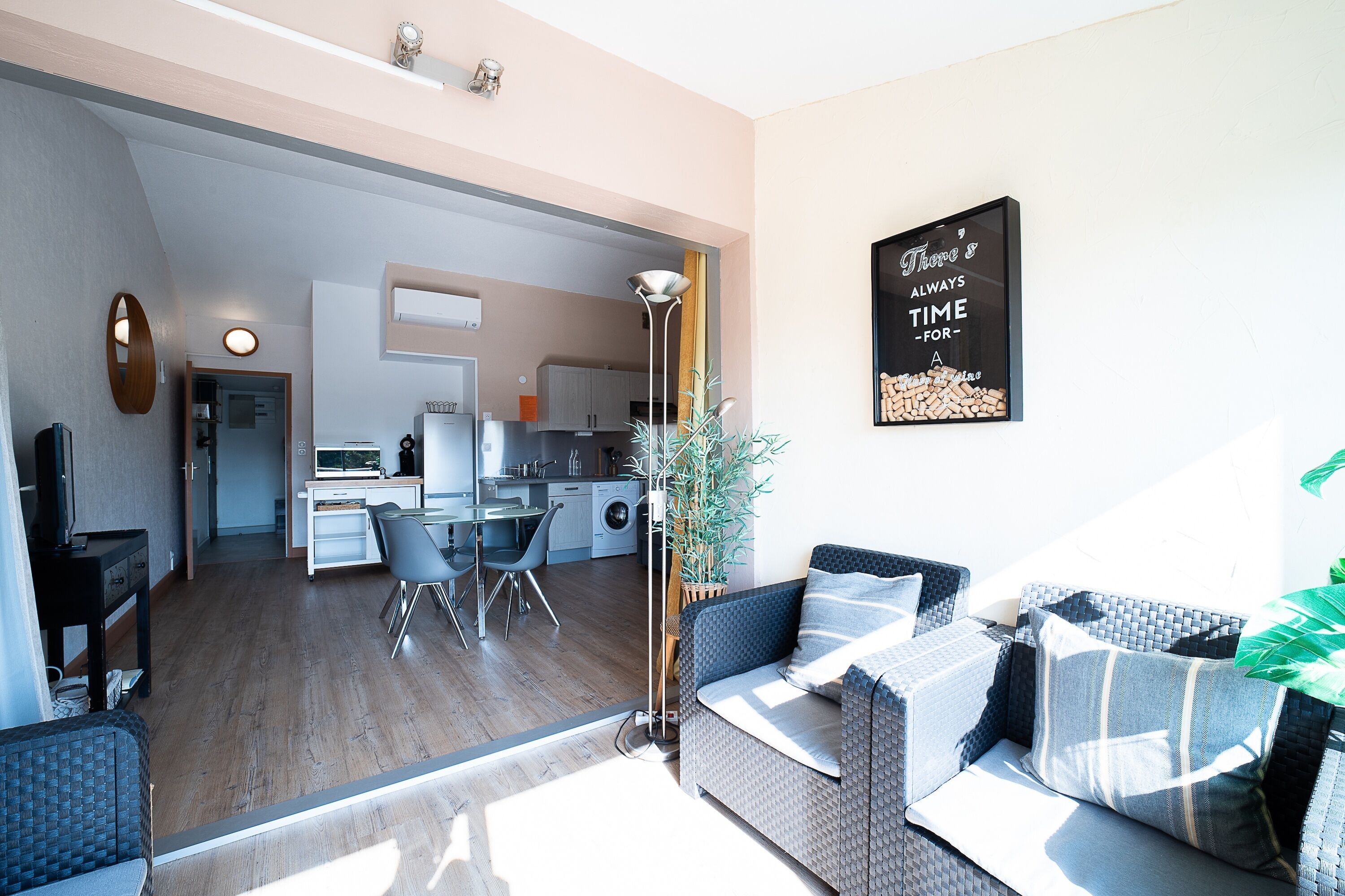 A modern living room with a sofa, a dining table, and a kitchen in the background.