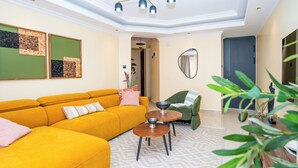 A modern living room with a yellow sofa, a green armchair, and a round wooden coffee table. - Tranquil 2-bedroom apartment in welcoming Nairobi neighborhood (Nairobi)
