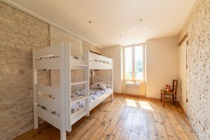 Ein Zimmer mit einem Etagenbett, einem Fenster mit Blick und Holzboden.