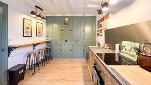 Una cucina con un piano di lavoro in legno, sgabelli da bar, un lavello e un fornello.