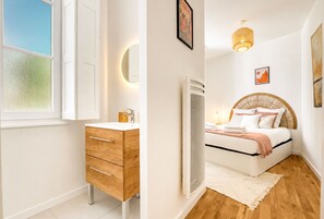 Ein Schlafzimmer mit einem Bett, einem Nachttisch und einem Fenster.