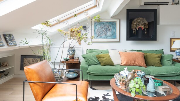 A modern living room with a sloped ceiling, a green sofa, a leather armchair, and various decorative items. - La Casa do pastore - appart sous les toits (Lyon)