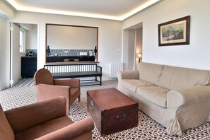 A modern living room with a sofa, armchair, and a small wooden chest. - L'Aiguillon - À 500 m de la plage (Saint-Cast-le-Guildo)