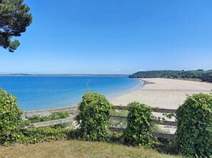 A beach with a clear view of the sea, a sandy shore, and greenery in the foreground. - L'Aiguillon - À 500 m de la plage (Saint-Cast-le-Guildo)