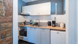 A compact kitchen with white cabinets, a microwave, a coffee maker, and a sink. - Le Refuge de Saint-Lary - 500m station de ski (Saint Lary-Soulan)