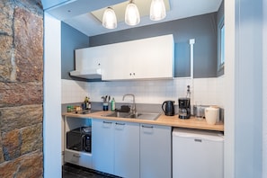 A compact kitchen with white cabinets, a microwave, a coffee maker, and a sink. - Le Refuge de Saint-Lary - 500m station de ski (Saint Lary-Soulan)