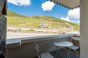 Ein Balkon mit Bergblick, einem Stuhl und einem Tisch.