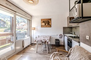 Et moderne køkken med spiseplads, store vinduer og et billede af en bjørn.