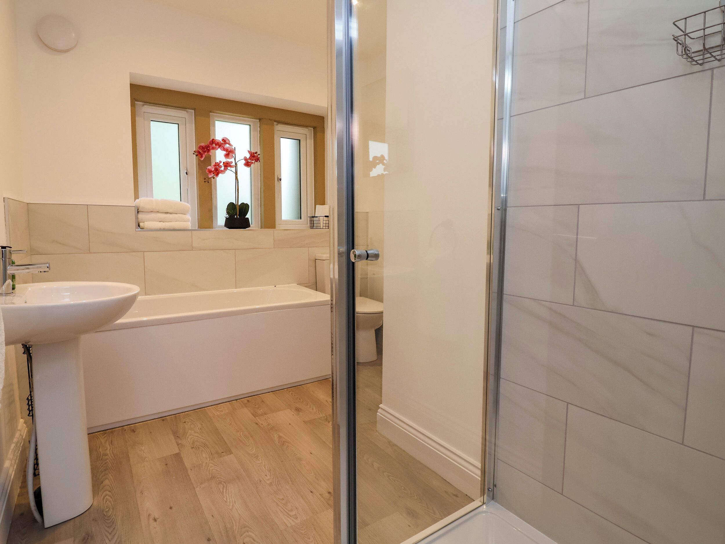 A bathroom with a bathtub, sink, and shower area.