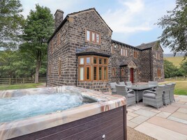 Un edificio de piedra con jacuzzi y mobiliario exterior.