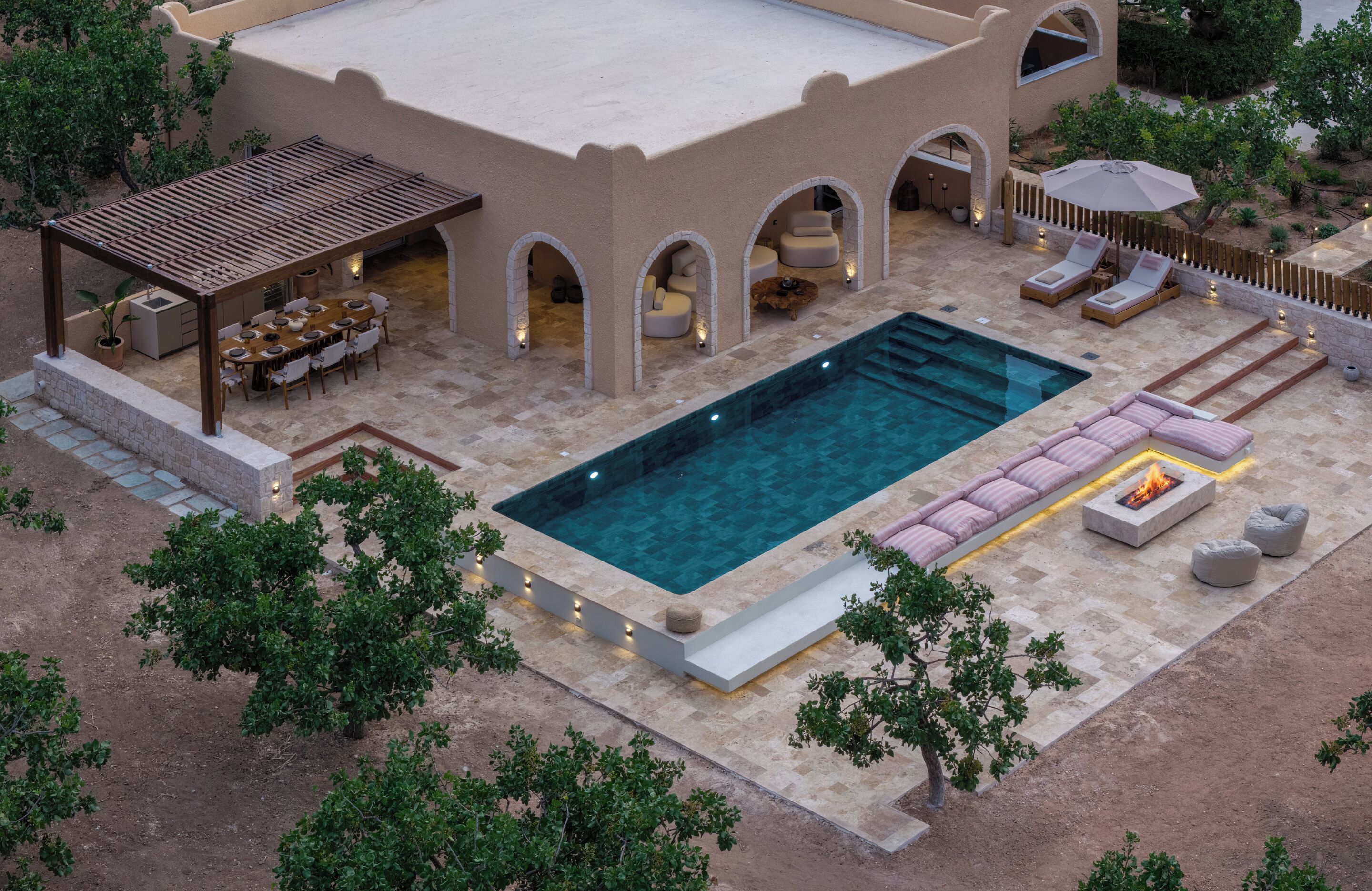 Zona junto a la piscina con piscina rectangular, mobiliario exterior y terraza cubierta.