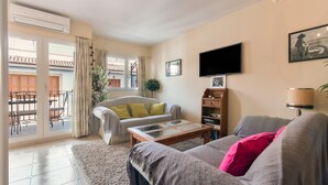 A living room with a sofa, a coffee table, a TV, and a bookshelf. - Apartment 'Piso En Jávea Puerto' with Sea View, Wi-Fi and Air Conditioning (Xàbia)
